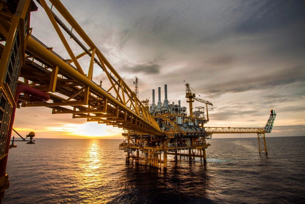 USA Offshore oil platform at sunset with reflective ocean waters.